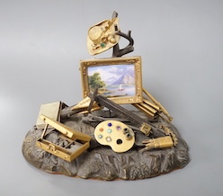 A 19th century Swiss gilt bronze, enamel, gem and paste mounted tableau of an artist's equipment, maker’s mark Malignon a Geneve, 11cm